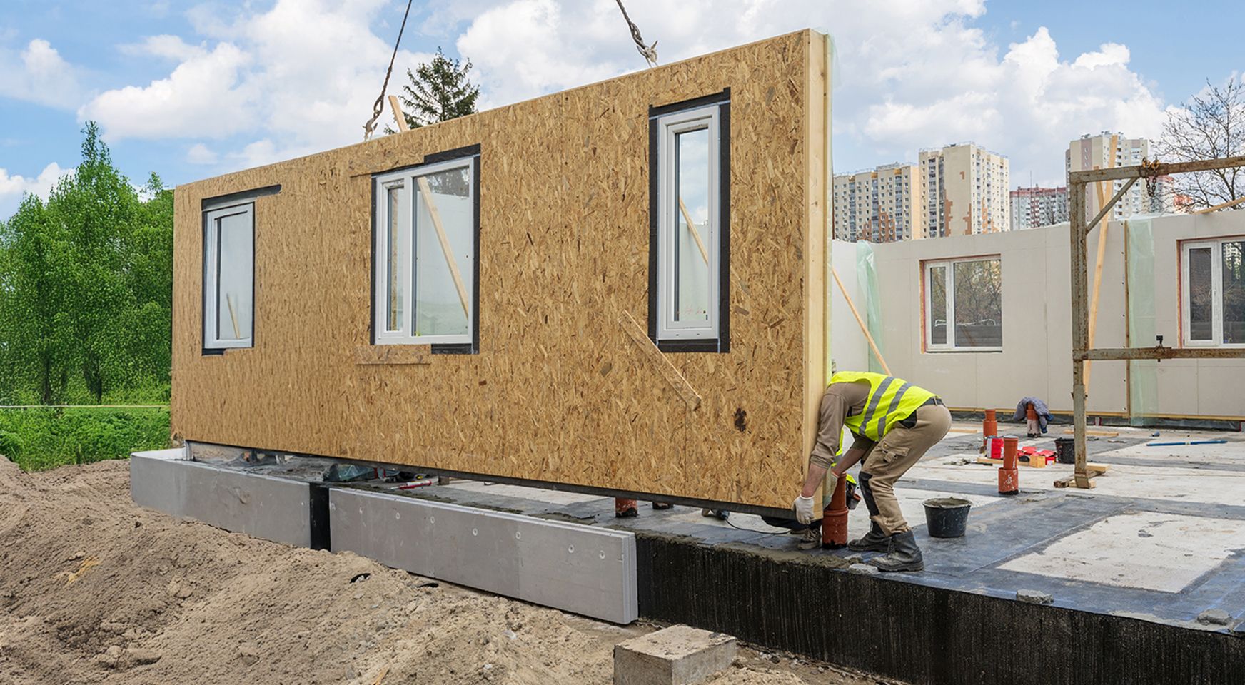 Process of construction new and modern modular house from composite sip panels. Worker man in special protective uniform wear working on building development industry of energy efficient property.